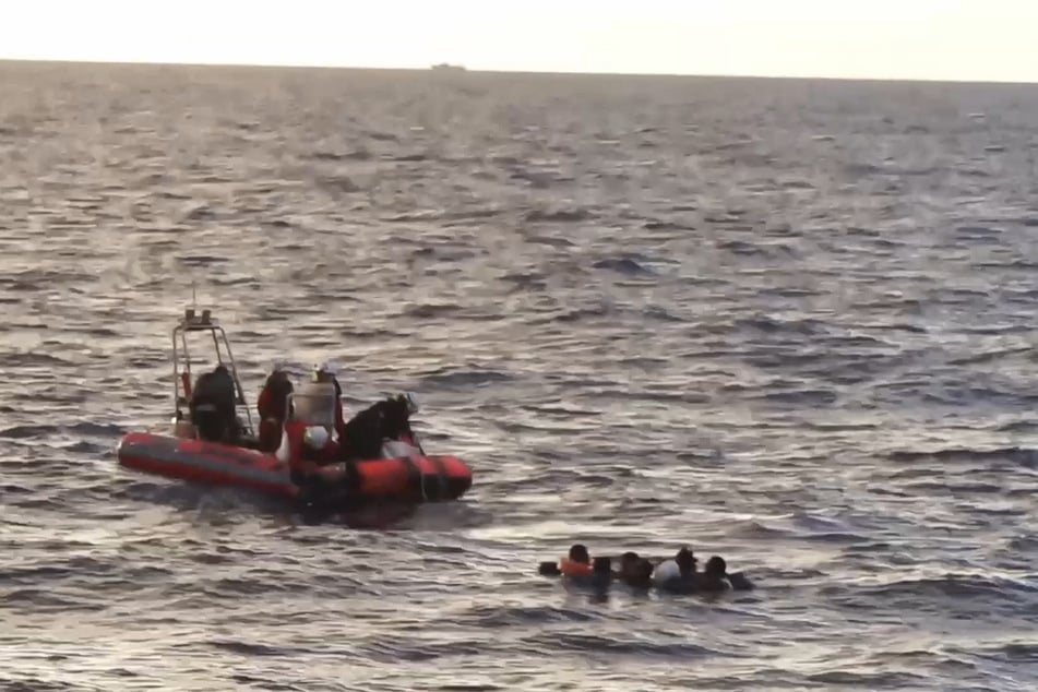 Mehrere Menschen treiben im offenen Meer.