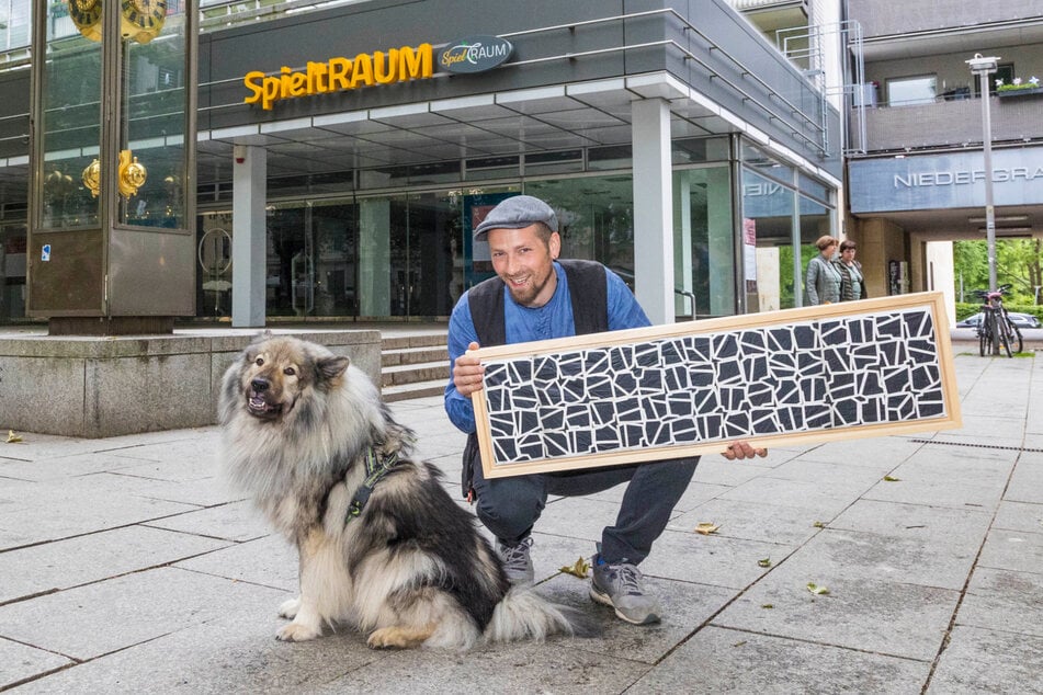 Alabaster Becher zeigt vor dem Ausstellungsraum das große Scherenschnitt-Original.