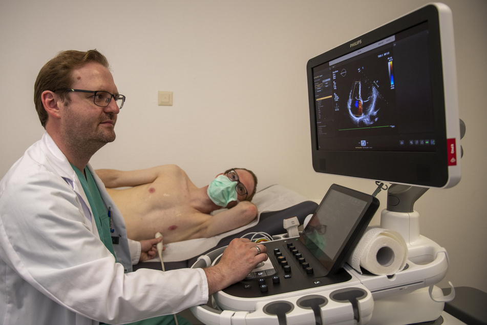 Der Internist Dominik Buckert nimmt in der Corona-Ambulanz des Universitätsklinikums an einem Patienten ein Ultraschall vor.