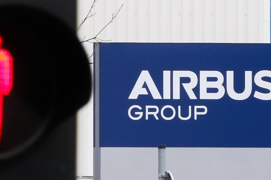 Eine Ampelmännchen steht vor dem Airbus-Gebäude auf rot.