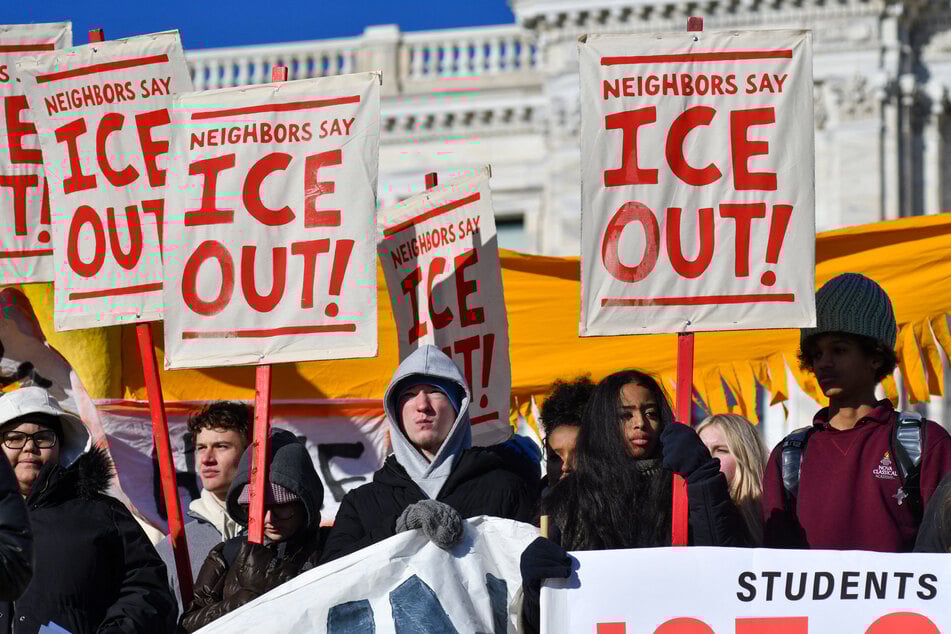 High school students raise signs reading "Neighbors Say ICE Out!" outside the State Capitol in St. Paul, Minnesota, on January 14, 2026.
