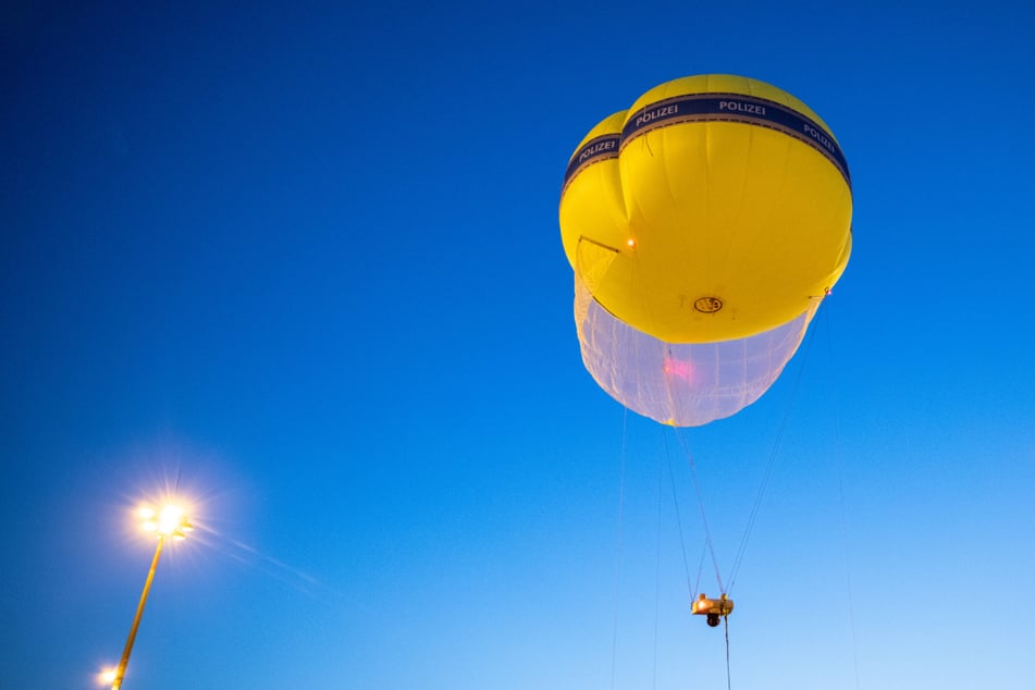 Ein mit Überwachungstechnik ausgestatteter Ballon der Polizei steigt auf dem Gelände der Internationalen Automobil-Ausstellung (IAA Mobility) in den Nachthimmel.