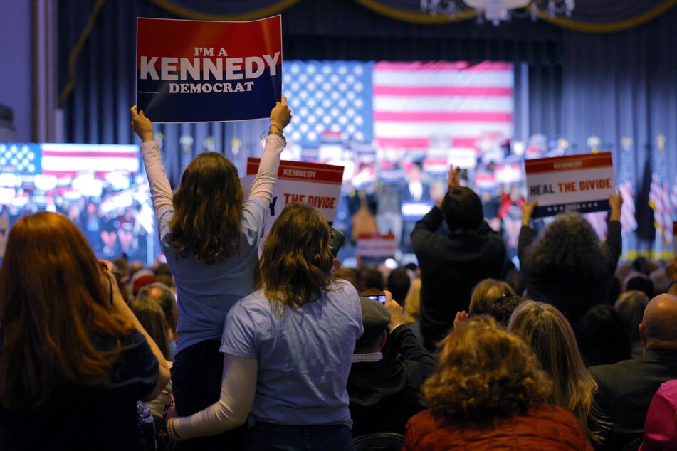 Supporters of Robert F. Kennedy Jr. hold up signs and snap pictures during his 2024 campaign announcement event in Boston, Massachusetts.