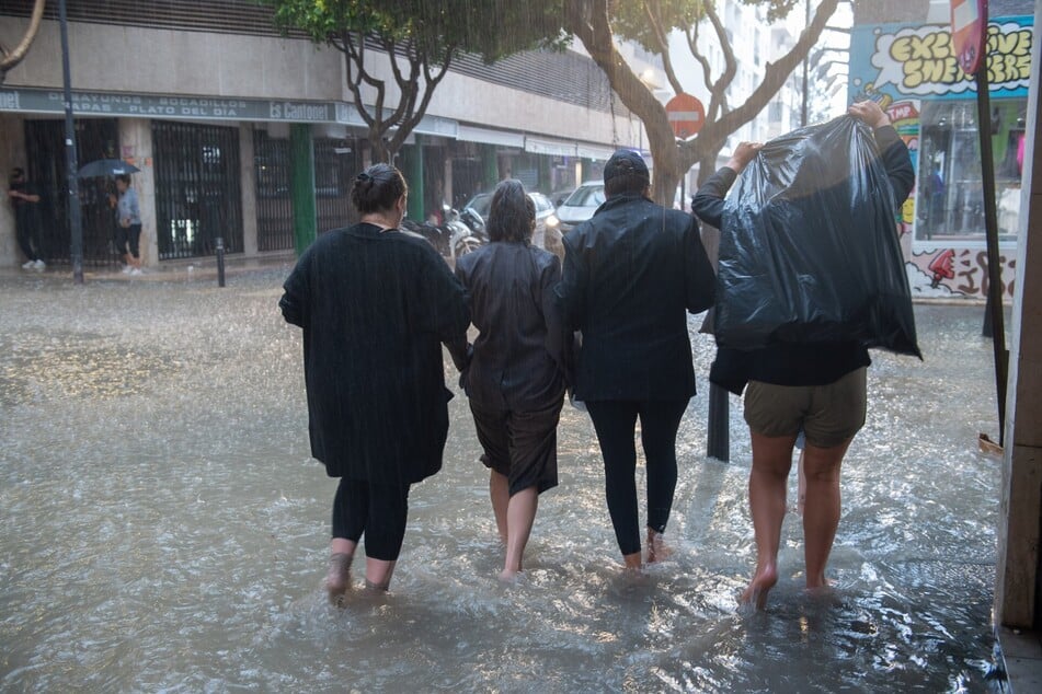 Barfuß kämpfen sich die Bewohner und Touristen durch die Wassermassen Spaniens.