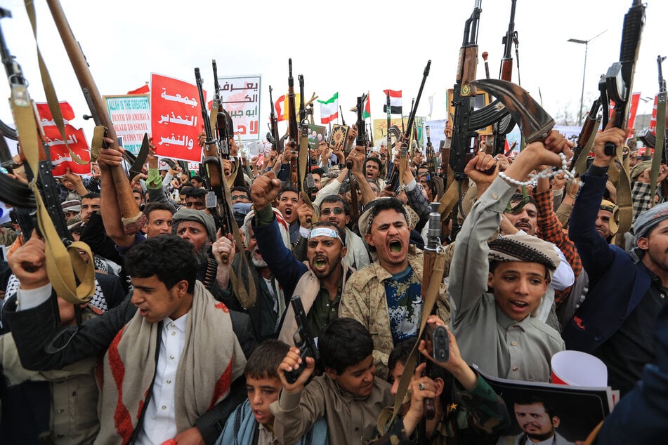 Armed Yemeni supporters of the Iran-backed Houthi movement brandish their weapons during a protest against what the group says are restrictions imposed by the Saudi-led coalition on Houthi-controlled areas of Yemen, in Sanaa on July 17, 2026.