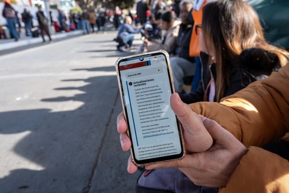 A person seeking asylum shows an updated message on the CBP One app mentioning that all appointments have been canceled as they wait for their CBP One appointment with US authorities before crossing through El Chaparral port in Tijuana, Mexico, on January 20, 2025.