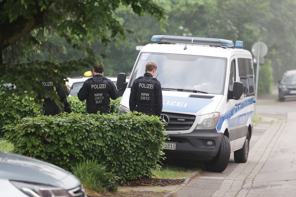 Die Polizei steht auf eine Strasse in Duisburg wo eine Wohnung durchsucht wird.