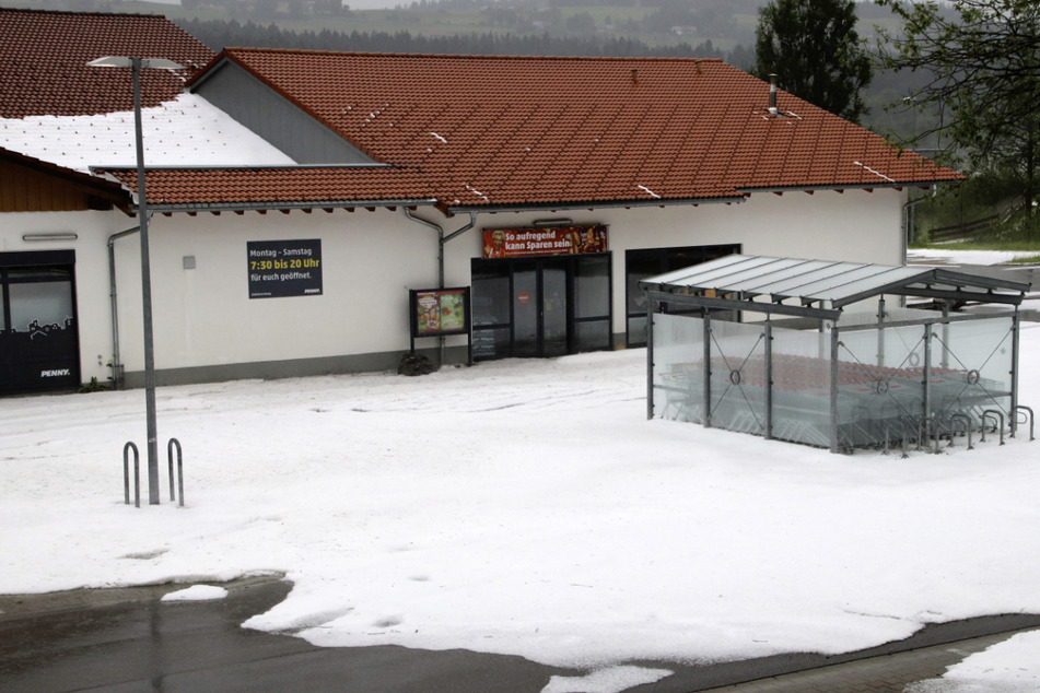 Es sieht aus, als hätte es geschneit. Ein Supermarktparkplatz in Weiler im Allgäu zeigt deutliche Spuren des Hagelschauers.