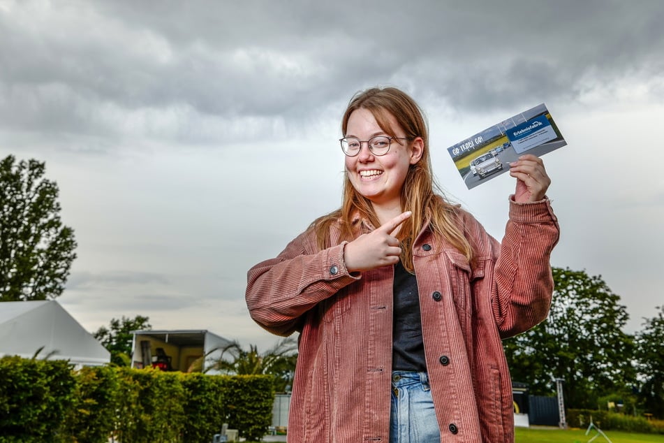 Auszubildende Annalena Weidauer (23) präsentiert den Gutschein für eine Trabi-Tour in Chemnitz.