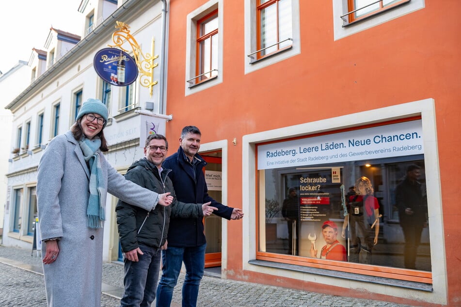 Wirtschaftsreferentin Klaudia Deuchert (46), Vermieter Thomas Tiebel (50) und der 1. Vorsitzende des Gewerbevereins Jens Richter (51) vorm Schaufenster, das die Firma "paso doble" gestaltet hat.