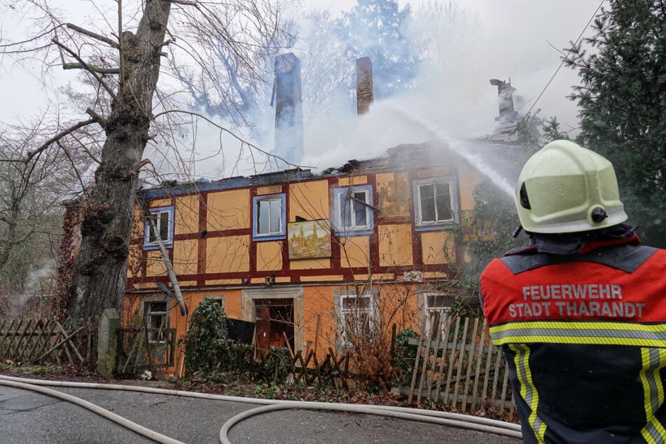 Ein Kamerad der Tharandter Stadtfeuerwehr löscht das gelbe Fachwerkhaus.