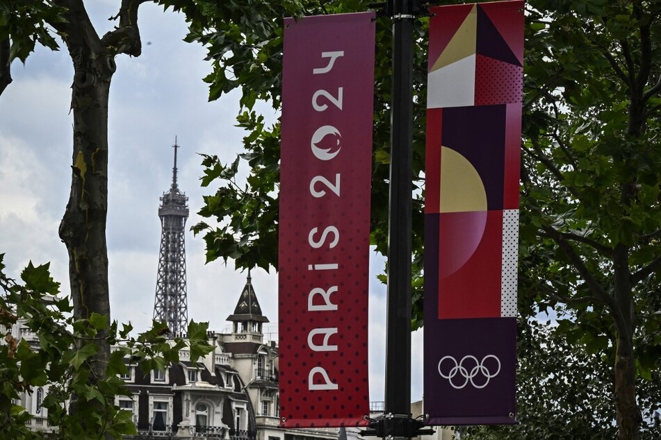 Banners for the upcoming Paris 2024 Olympics are seen along a road near the Eiffel Tower.