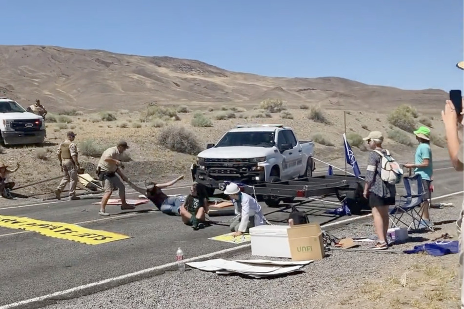 Law enforcement officers violently clear the climate activists' barricade, making way for festival attendees.