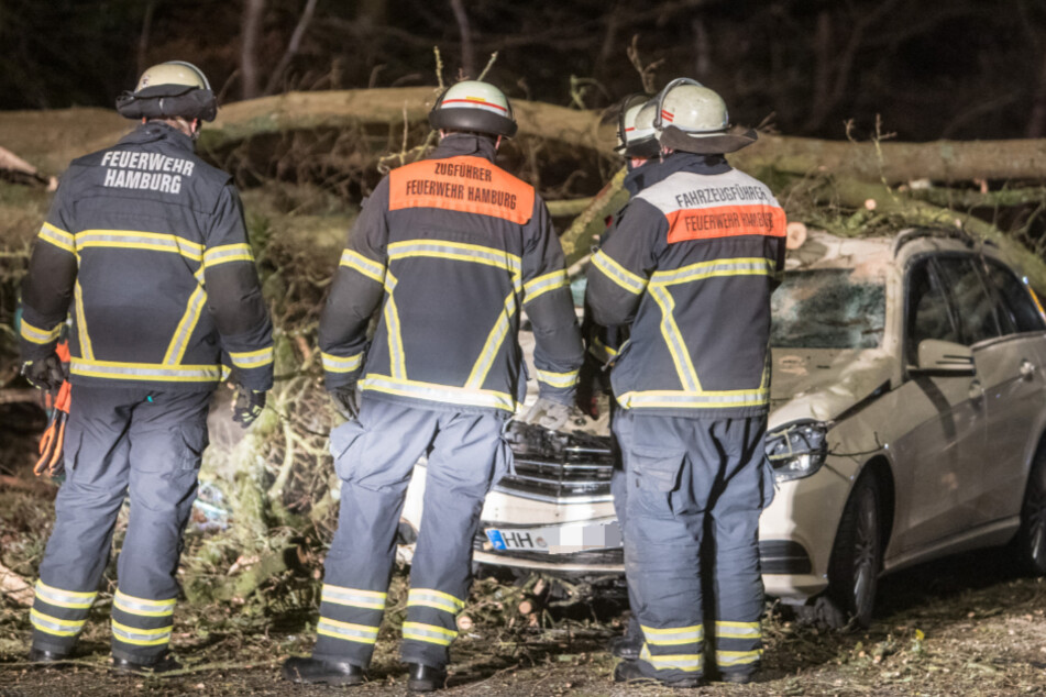 Einsatzkräfte der Feuerwehr stehen an Unfallort.