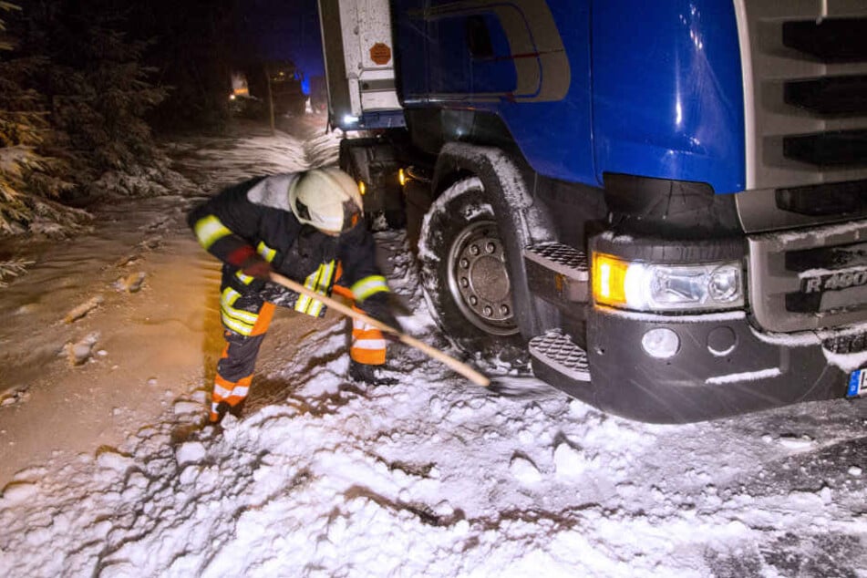 Ein Feuerwehrmann versucht einen Lkw zu befreien.