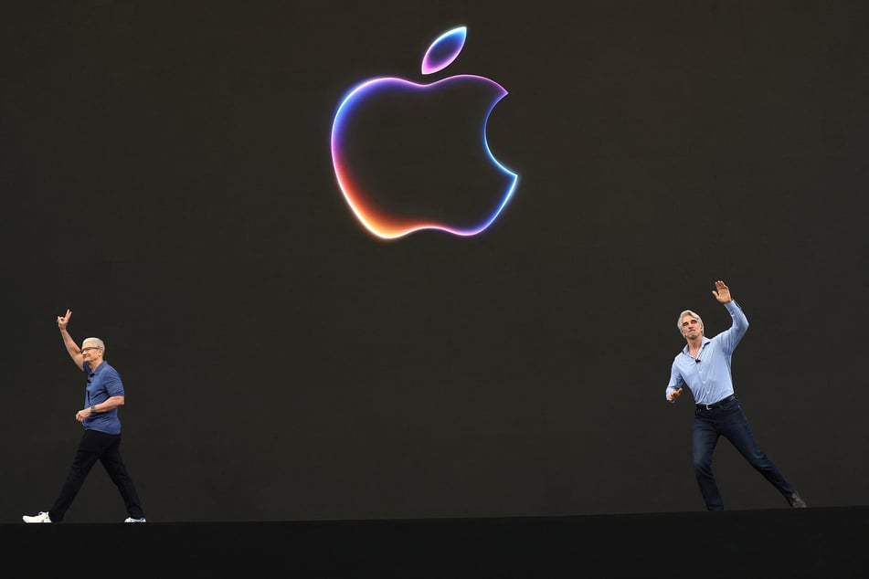 Apple CEO Tim Cook (l.) and Apple senior vice president of software engineering Craig Federighi (r.) greet attendees at the start of the Apple Worldwide Developers Conference (WWDC) on Monday in Cupertino, California.