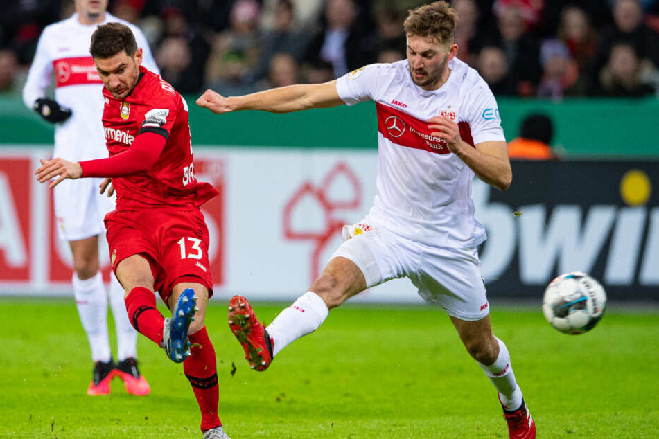 Leverkusens Lucas Alario (l) schießt den Ball gegen Stuttgarts Nathaniel Phillips auf das Tor.