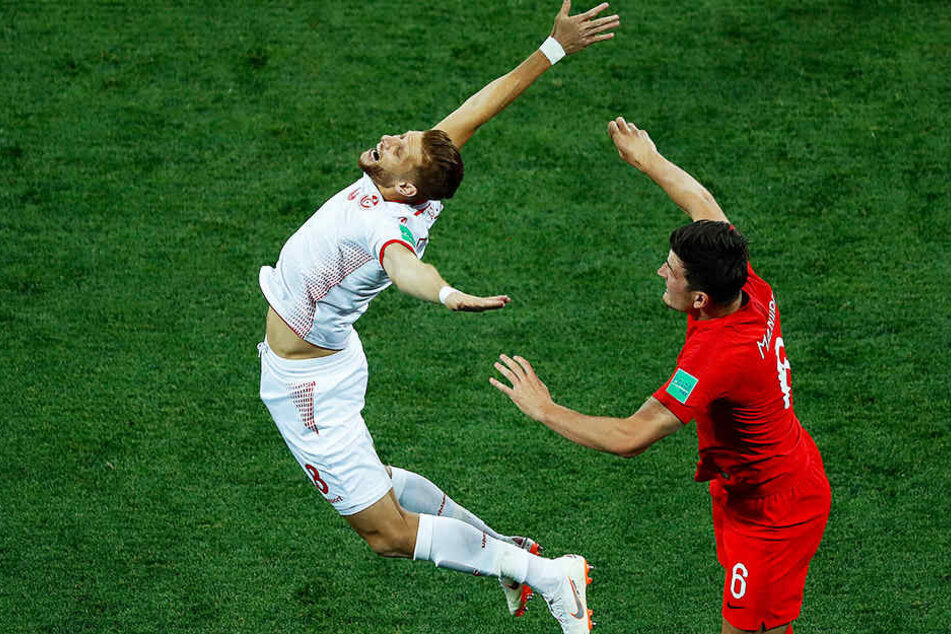 Ist das noch Fußball oder was? Der Tunesier Rami Bedoui (l) macht nach einem kleinen Schubser seines englischen Gegenspielers Harry Maguire (r.) den sterbenden Schwan.
