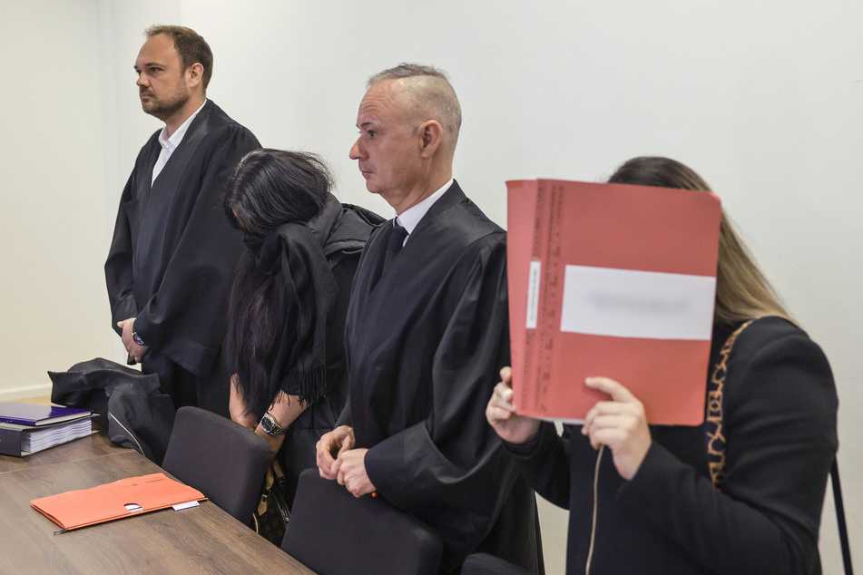 Der Rechtsanwalt Christian Beckmann (v. l. n. r.), eine angeklagte Erzieherin, der Rechtsanwalt Andre Wallmüller und eine zweite angeklagte Erzieherin stehen im Sitzungssaal des Amtsgerichts.