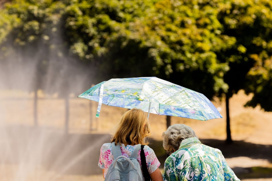 Der Regenschirm dient zurzeit nur als Sonnenschutz: In NRW bleibt es vorerst trocken und heiß.