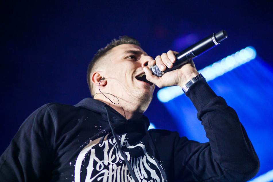 Gzuz rappt bei einem Konzert.