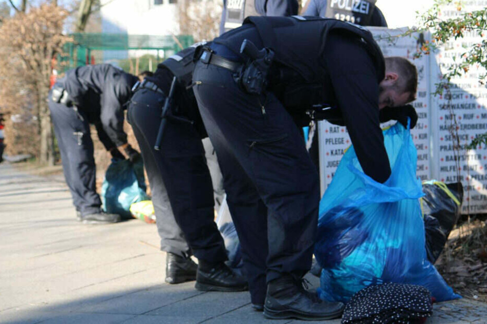 Polizisten durchsuchen die Beutel.
