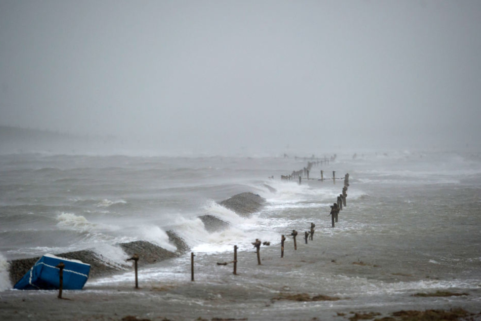 Ein Deich der nordfriesischen Hallig Langeneß wird während eines Orkans überspült. (Archivbild)