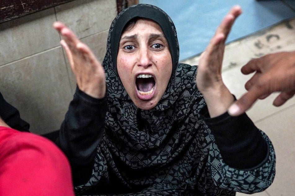 A Palestinian woman reacts as she sits outside the trauma ward after a child relative being treated there died in the aftermath of bombardment on their displaced persons camp, at the Aqsa Martyrs Hospital in Deir el-Balah in the central Gaza Strip.