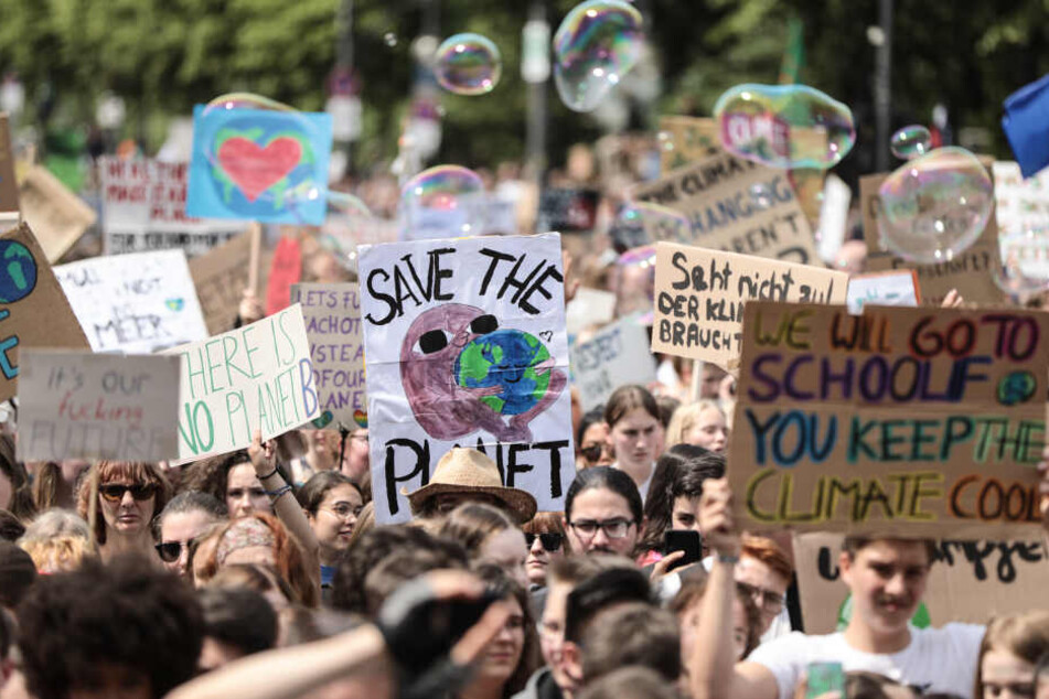 Schüler demonstrieren mit Protestplakaten während des Fridays for Future - Klimastreiks für die Umsetzung der Pariser Weltklimaabkommens.