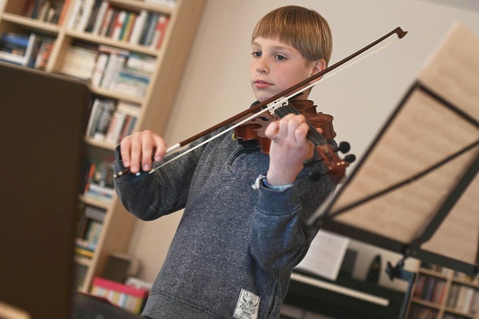 Benjamin übt vor seinem Computer mit seiner Geige. Seinen Lehrer hat er schon seit mehreren Monaten nicht mehr in echt gesehen.