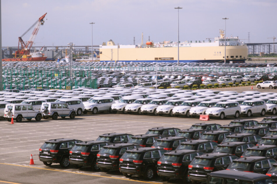 Neuwagen stehen auf einem Parkplatz in der Nansha-Handelszone am Hafen geparkt.