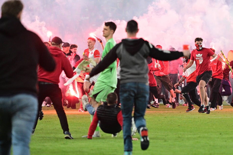 Die Spieler beider Teams waren beim Platzsturm noch auf dem Rasen. Gut zu sehen: Sparta-Torhüter Jakub Surovcik (23) wird von einem Hooligan umgegrätscht.