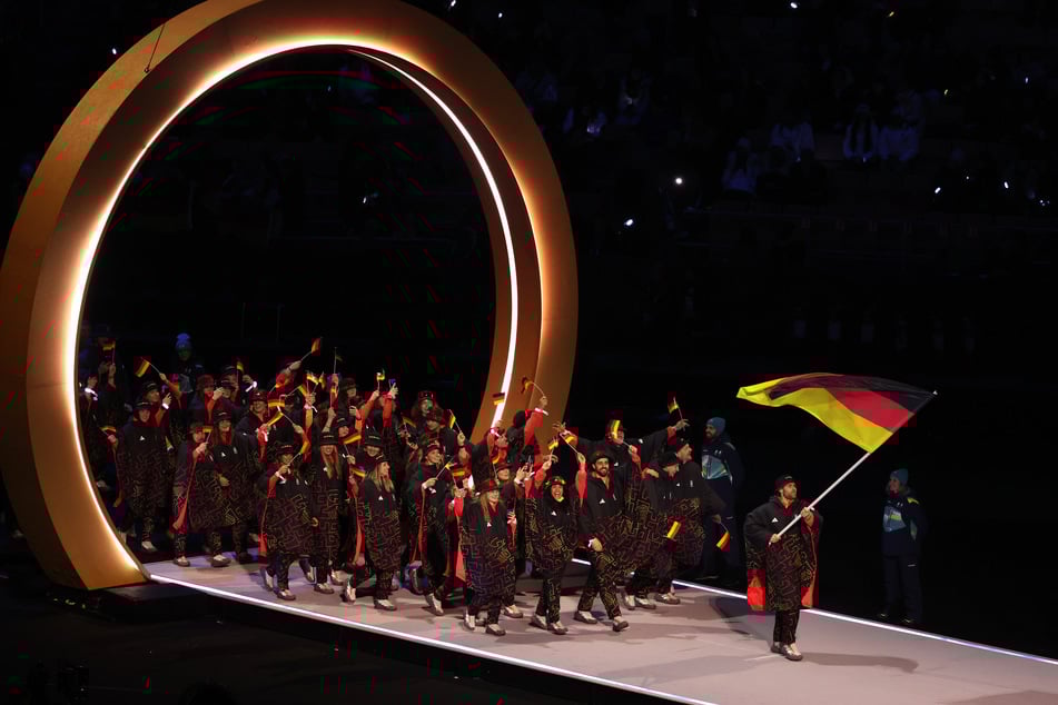 Angeführt von Fahnenträger Leon Draisaitl (30) laufen die deutschen Athleten ein.