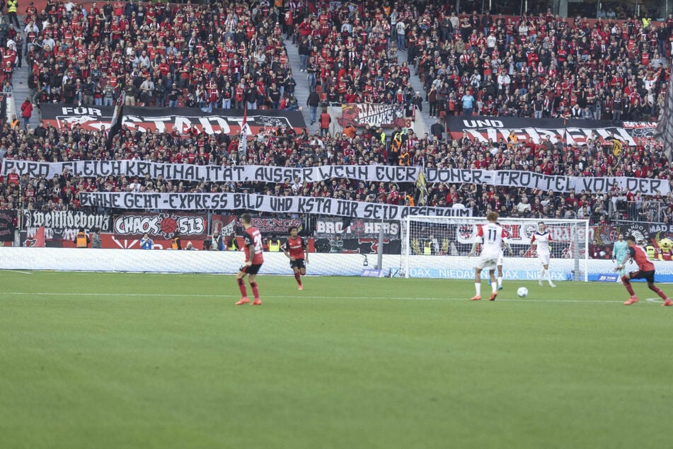 Mit einem großen Banner haben die Fans der Werkself im Spiel gegen Eintracht Frankfurt gegen Lukas Podolski und die Kölner Medien geschossen.