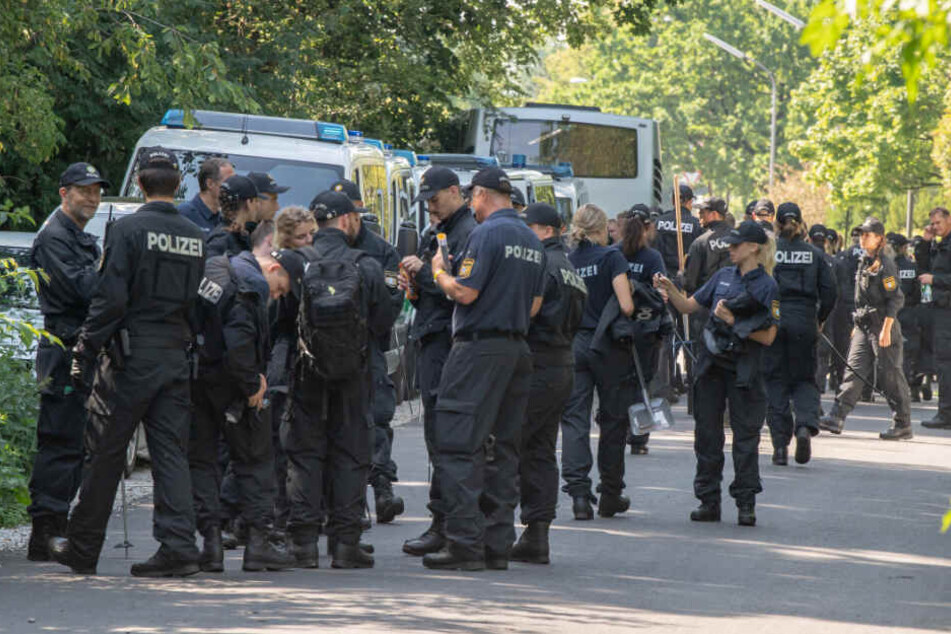 Polizisten sammeln sich auf einer Straße, um anschließend weiter in einem Forst bei München nach den zwei Leichen zu suchen.