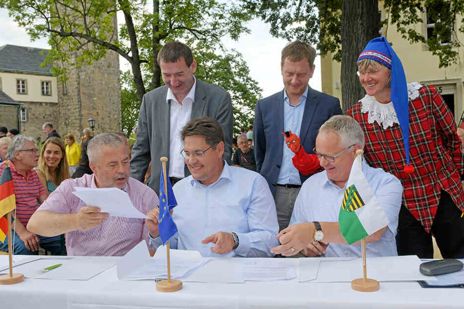 Landrat Michael Geissler (59, CDU, vorn, links) Hohnsteins Bürgermeister Daniel Brade (38, SPD, vorn, Mitte), Sachsens Ministerpräsident Michael Kretschmer (44, CDU, hinten, Mitte) und andere Vertreter unterzeichneten die Absichtserklärung.