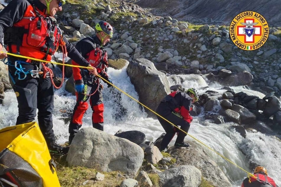 Einsatzkräfte der italienischen Bergrettung seilen sich an einem Wildbach in der Nähe des Fellaria-Gletschers ab. In einer bergigen Gegend in der norditalienischen Region Lombardei sind am Donnerstag die Leichen von zwei Italienerinnen gefunden worden.