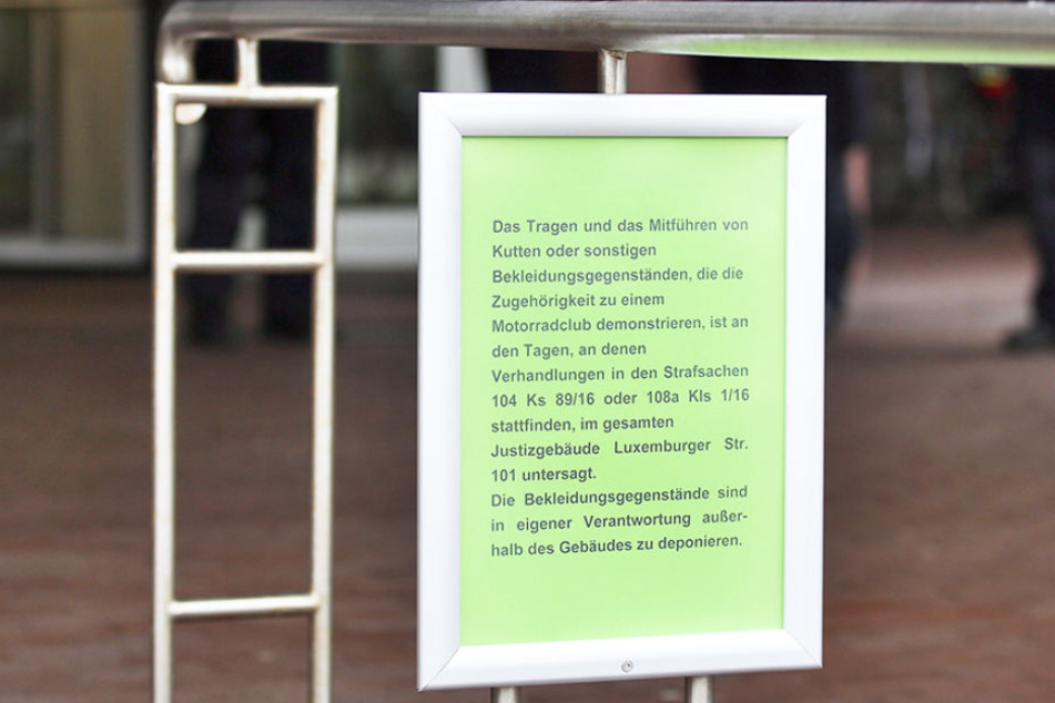 Ein Infozettel informiert vor dem Gerichtsgebäude, dass das Tragen und Mitführen von Kutten und sonstigen Bekleidungsgegenständen, die die Zugehörigkeit zu einem Motorradclub demonstrieren, im Gerichtsgebäude verboten ist.