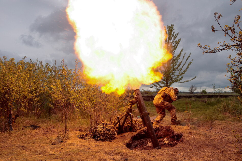 A Ukrainian serviceman fires with a mortar, as Russia's attack on Ukraine continues after 100 days of devastating combat.