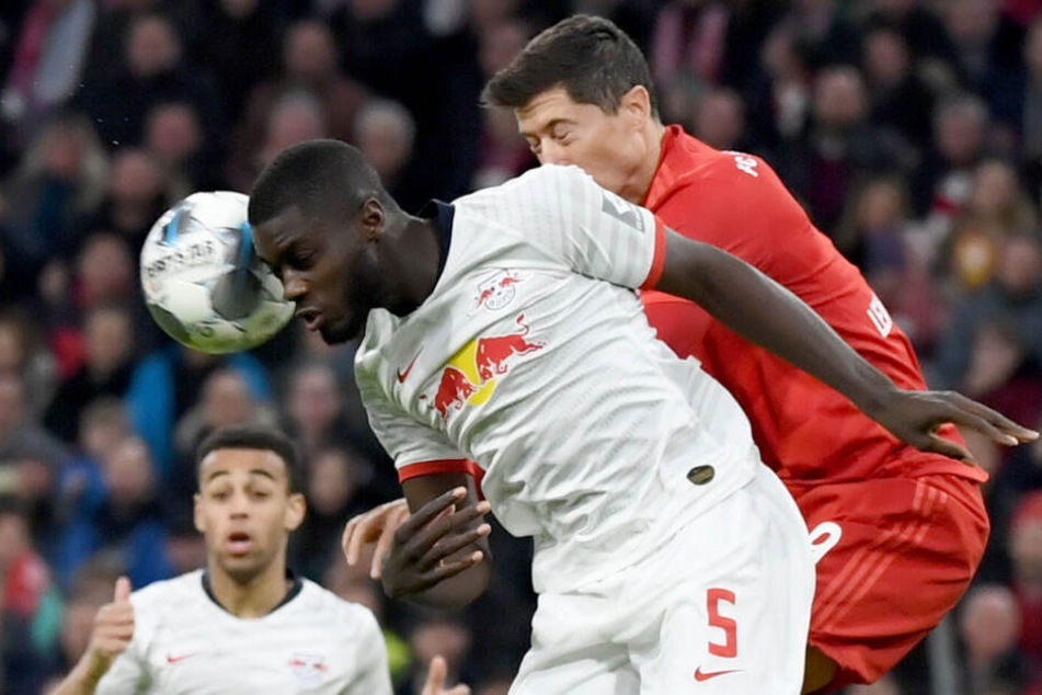 Robert Lewandowski (r) im Kopfballduell mit Dayot Upamecano.