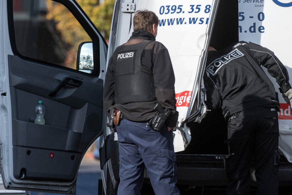 Polizeibeamte durchsuchen den Geldtransporter nahe dem Berliner Alexanderplatz.