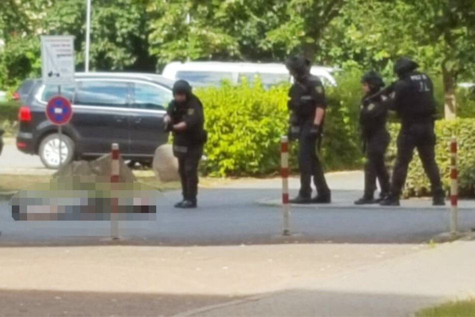 Ein Polizist beugt sich über eine am Boden liegende Person.