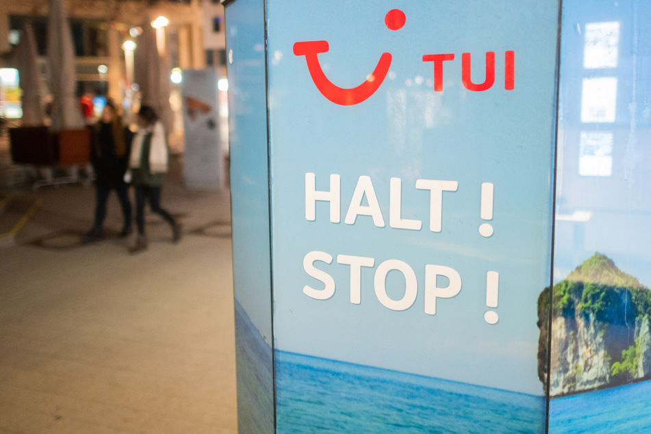 Die Worte "Halt! Stop!" stehen vor einem TUI-Reisebüro. Der Reisekonzern hat mit einem dramatischen Rückgang der Buchungen zu kämpfen.