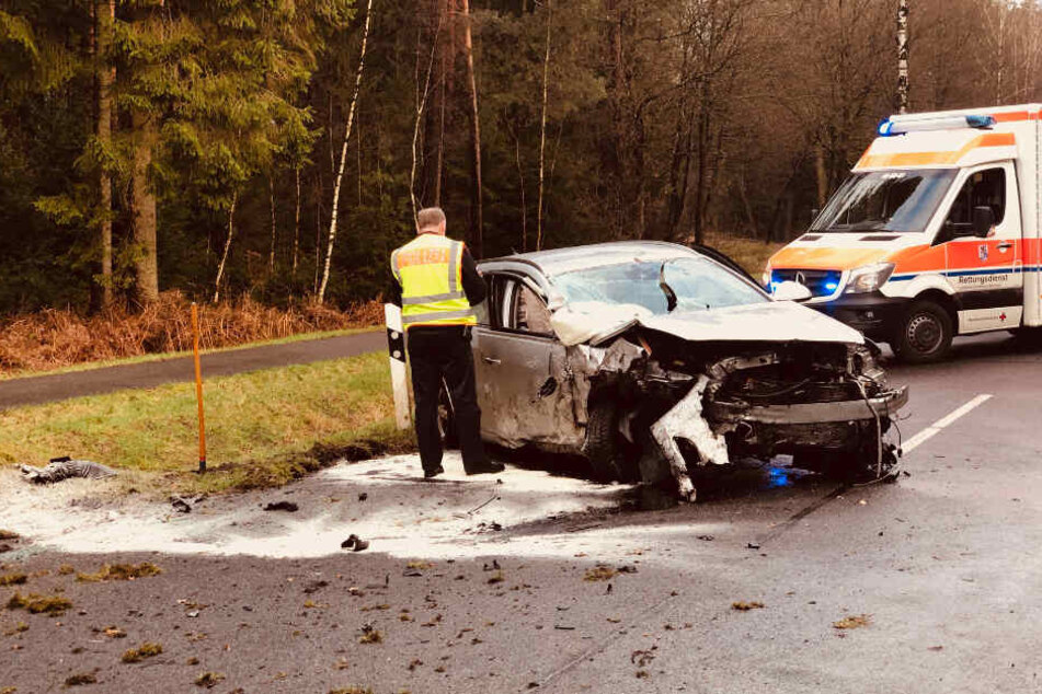 Ein Polizist steht an dem Autowrack.