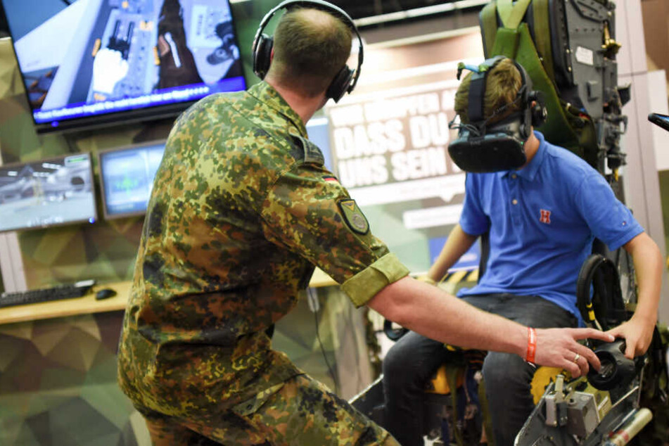 Ein Soldat zeigt einem Besucher der Gamescom einen Flugsimulator der Bundeswehr.