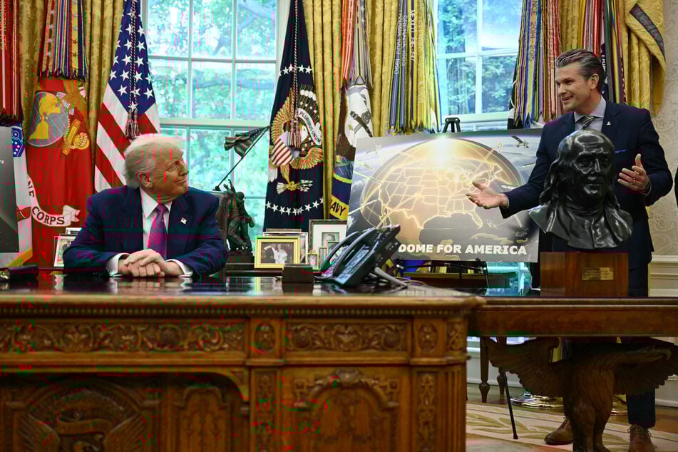 President Donald Trump (l.) listens to US Secretary of Defense Pete Hegseth (r.) speak about the Golden Dome missile defense shield, in the Oval Office of the White House on May 20, 2025, in Washington, DC.