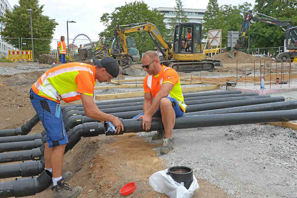Bernhard Kahnert (29, l.) und Roberto Semsch (36) verlegen eine Druckleitung für den Brunnen.