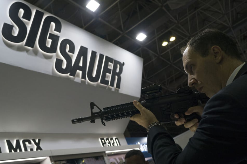 Ein Mann testet ein Sig Sauer-Gewehr, das auf der Waffenmesse LAAD Defence and Security International Exhibition in Rio De Janeiro, Brasilien ausgestellt wird.