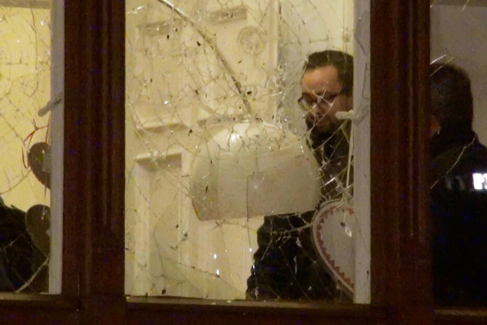 Nach dem Anschlag auf seine Wohnung spricht Justizminister Sebastian Gemkow (CDU) am Tatort mit Polizisten.