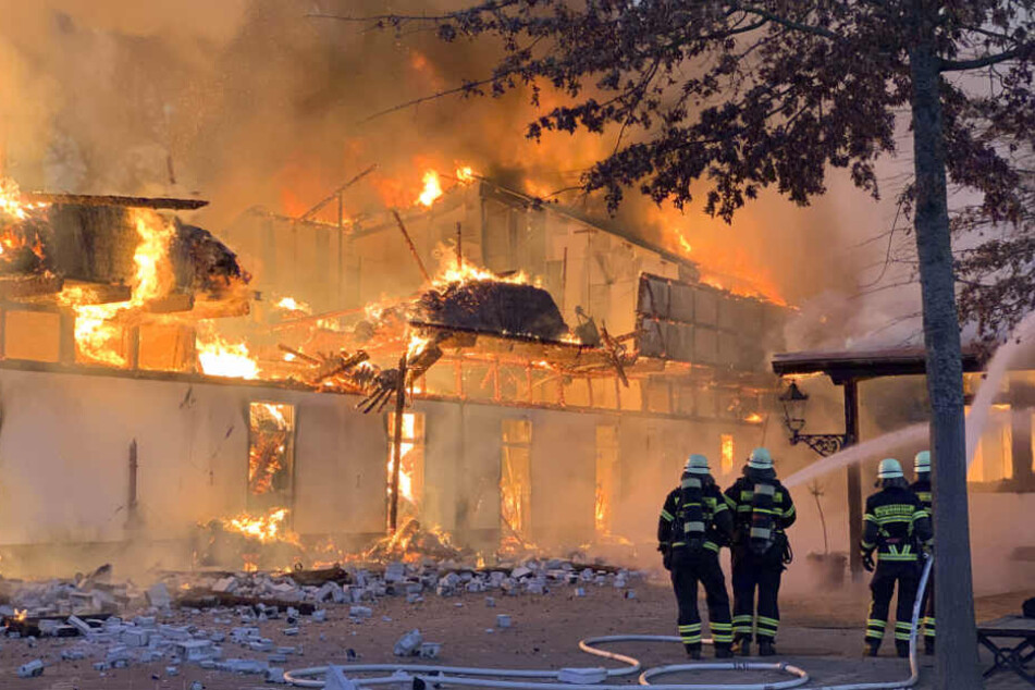 Einsatzkräfte versuchen die Flammen daran zu hindern, auf ein weiteres Gebäude überzugreifen.